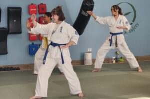 3 students moving in a karate stance with strikes